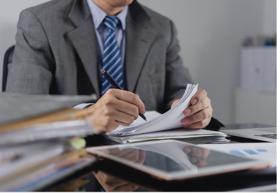 Senior professional reviewing a merger due diligence checklist with one key question highlighted among the documents.